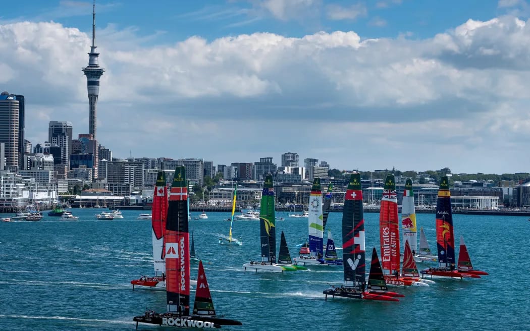 SailGP boats foiling on Waitematā Harbour with Auckland skyline