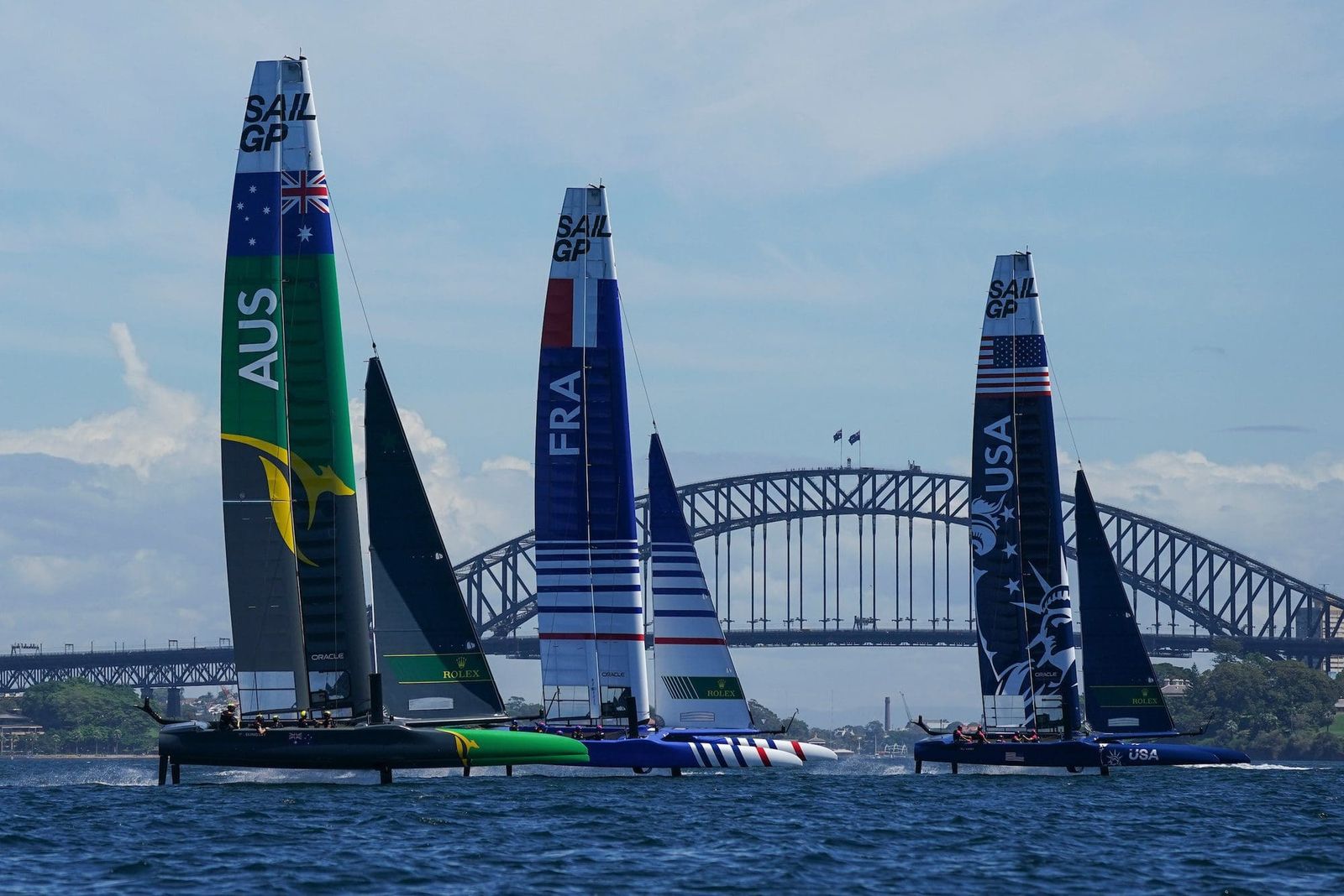 SailGP boats foiling on Sydney Harbour with Opera House and Harbour Bridge